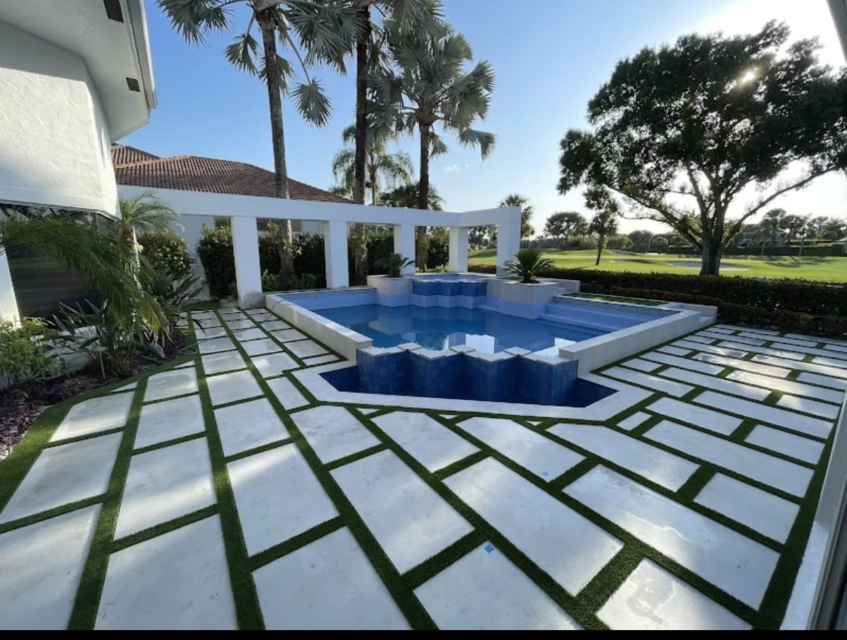 Completed Jupiter backyard with large-format pavers and artificial turf joints