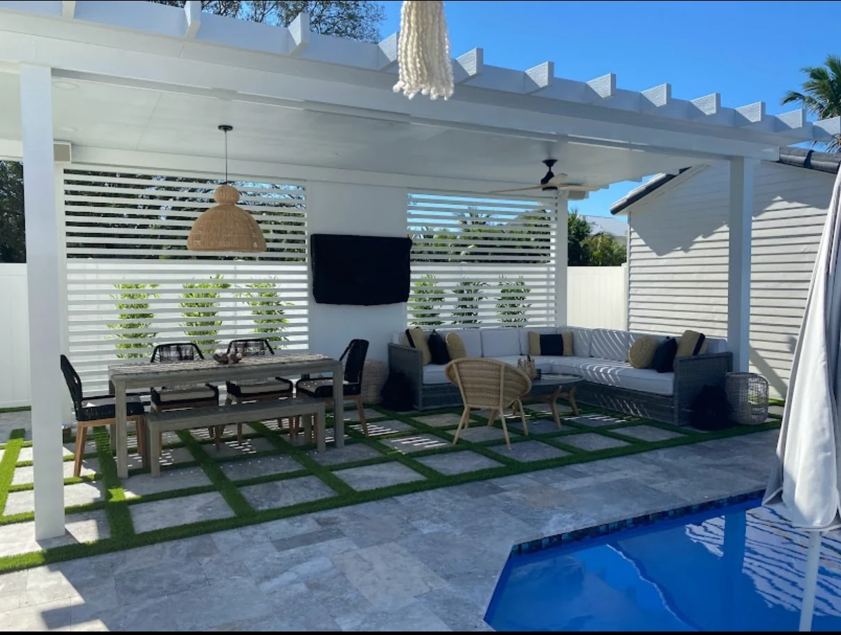 Covered Palm Beach County outdoor living area with geometric pavers and artificial turf