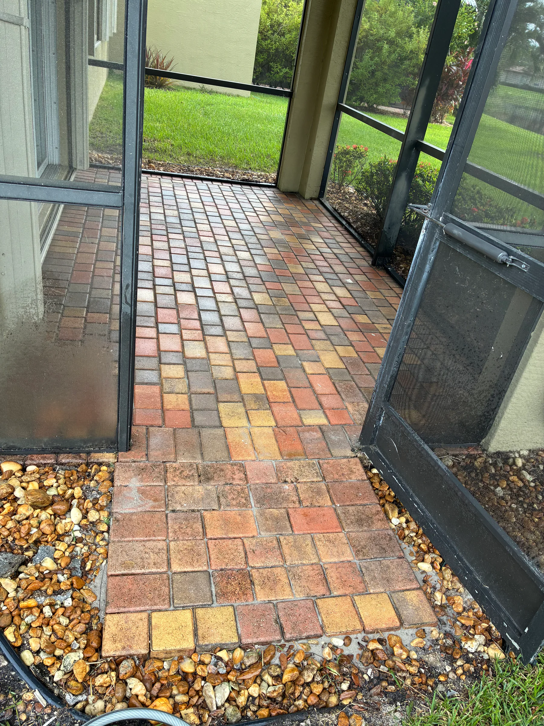 Reset screened patio pavers after drainage-related elevation repair in Delray Beach