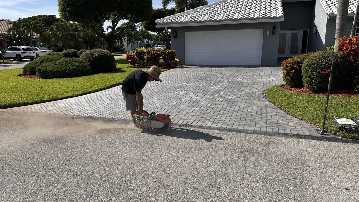 Repair limits being cut along a Boynton Beach paver driveway apron