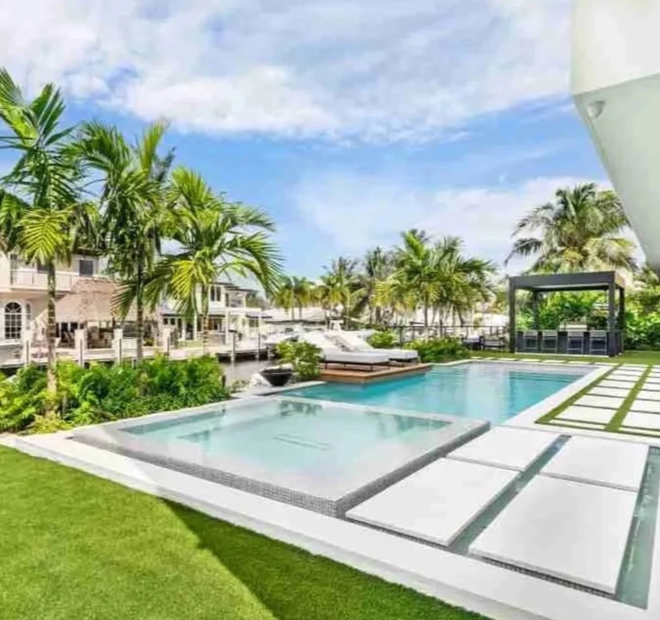Light natural stone pool deck with tropical landscaping in Palm Beach County