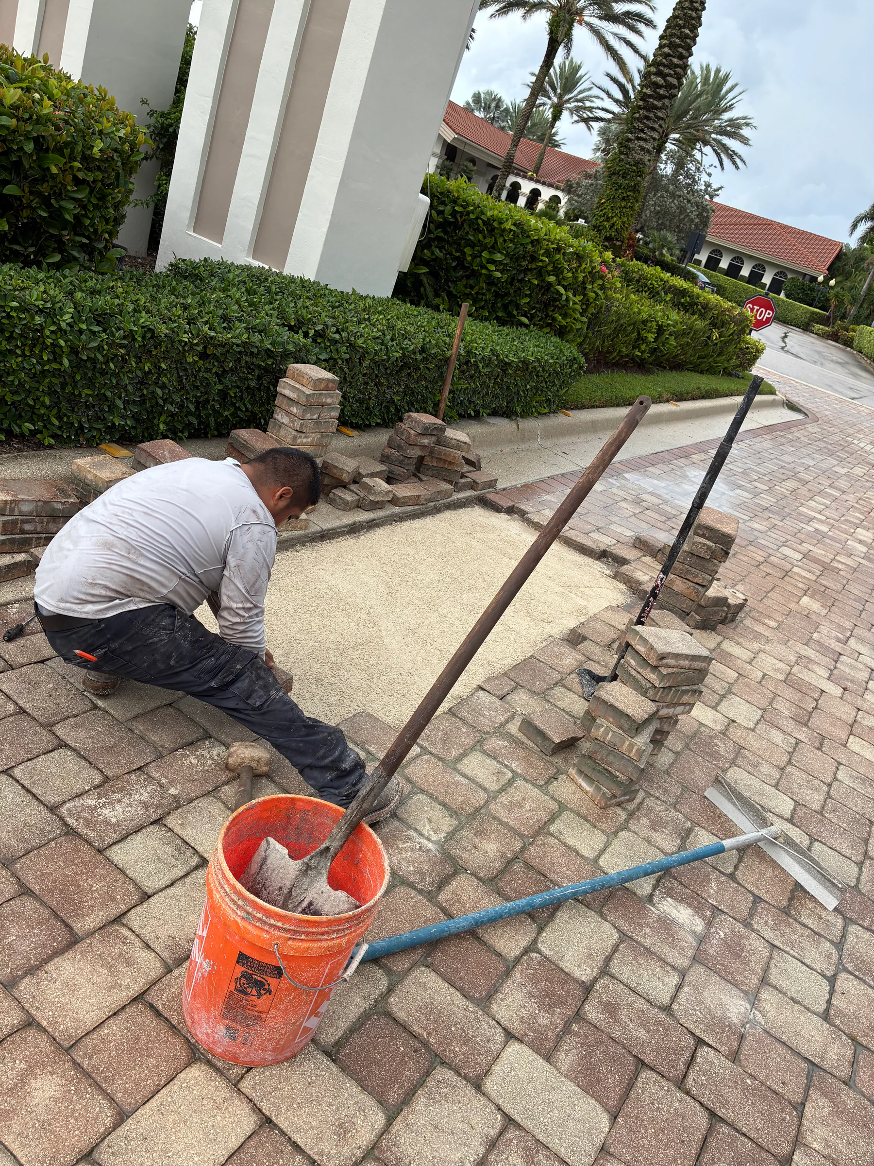 Pavers removed and staged while bedding material is prepared during a Delray Beach driveway repair