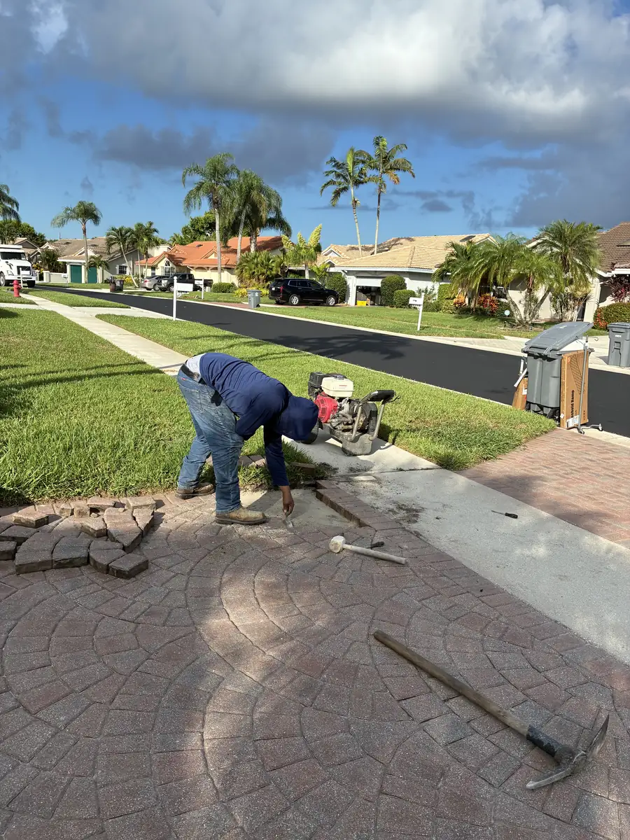 Boca Raton driveway pavers being lifted and staged during a localized sinking paver repair